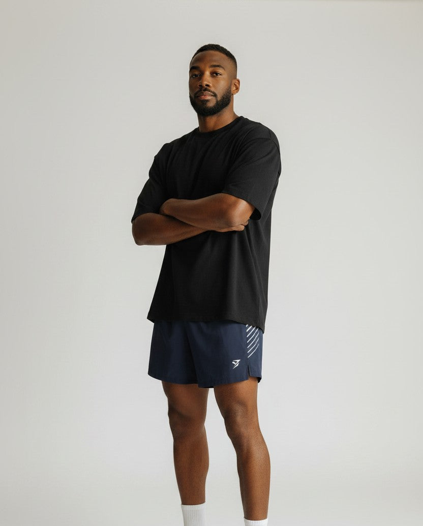 Stryvn men's navy blue athletic performance shorts with white side stripe detail and logo.